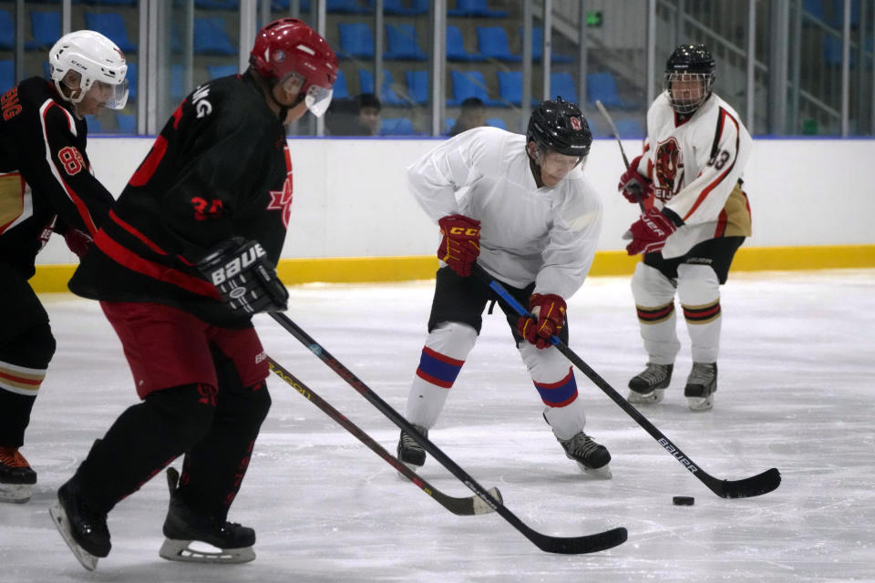 Members of the "1979" hockey club compete during a hockey match at a rink in Beijing, Wednesday, Jan. 12, 2022. Spurred by enthusiasm after China was awarded the 2022 Winter Olympics, the members of a 1970s-era youth hockey team, now around 60 years old, have reunited decades later to once again take to the ice. (AP Photo/Mark Schiefelbein)