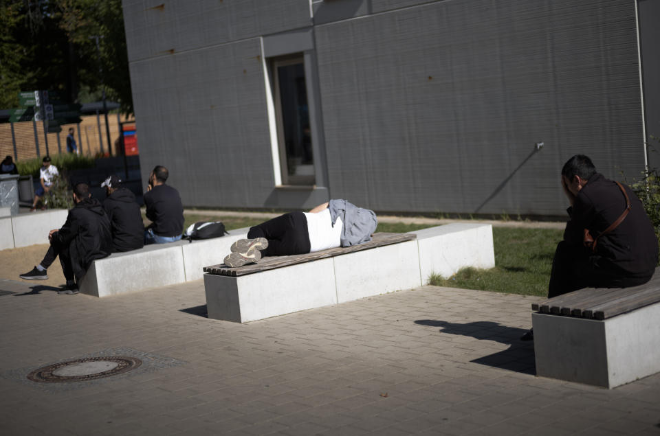 New arrived migrants rest as they wait for their results of a medical check at the central registration for asylum seekers in Berlin, Germany, Monday, Sept. 25, 2023. Across Germany, officials are sounding the alarm that they are no longer in a position to accommodate migrants who are applying for asylum. (AP Photo/Markus Schreiber)