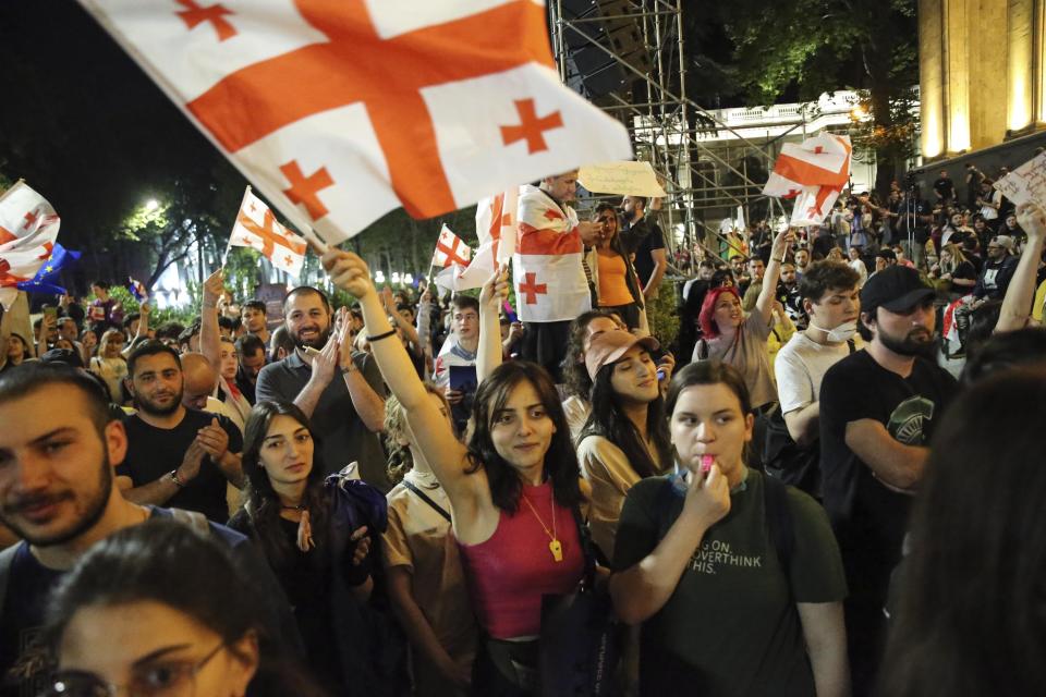 Demonstrators wave Georgian national flag during an opposition protest against "the Russian law" near the Parliament building in Tbilisi, Georgia, on Wednesday, May 1, 2024. Protesters denounce the bill as "the Russian law" because Moscow uses similar legislation to stigmatize independent news media and organizations critical of the Kremlin. (AP Photo/Zurab Tsertsvadze)