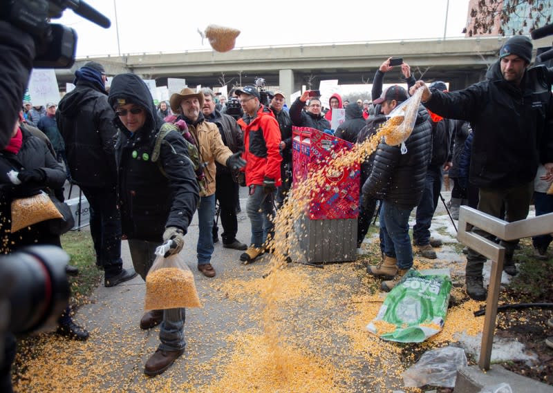 Farmers dump bags of corn grain in front of the Papineau riding office of PM Trudeau, as they protest the lack of propane due to the CN Rail strike in Montreal