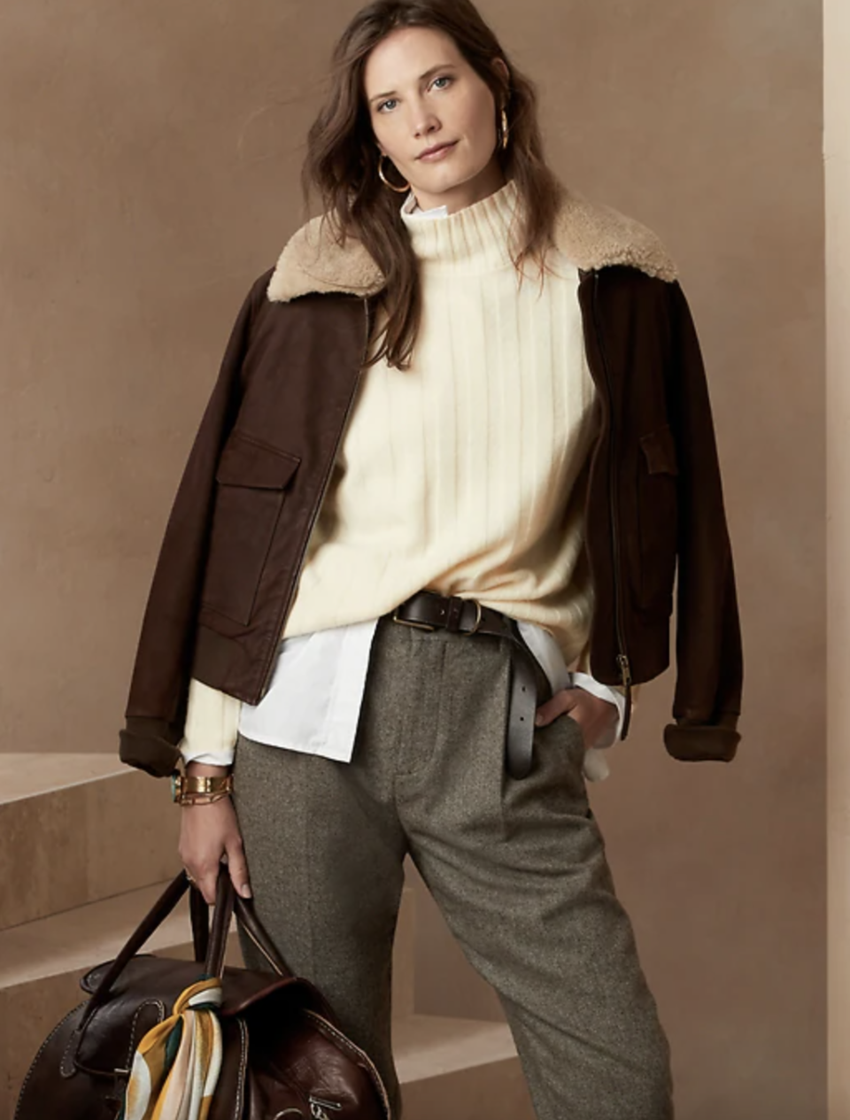 model in green pants, brown jacket, and white Italian Merino Turtleneck Sweater (Photo via Banana Republic)