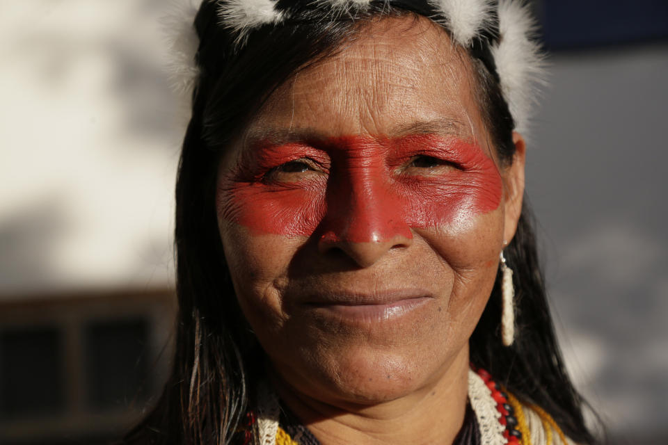 A Waorani woman smiles as she marches with others to a courthouse to attend the ruling on a lawsuit filed by the Waoranis against the Ministry of Non-Renewable Natural Resources for opening up oil concessions on their ancestral land, in Puyo, Ecuador, Friday, April 26, 2019. The judge went on to rule in favor of the Waoranis. (AP Photo/Dolores Ochoa)