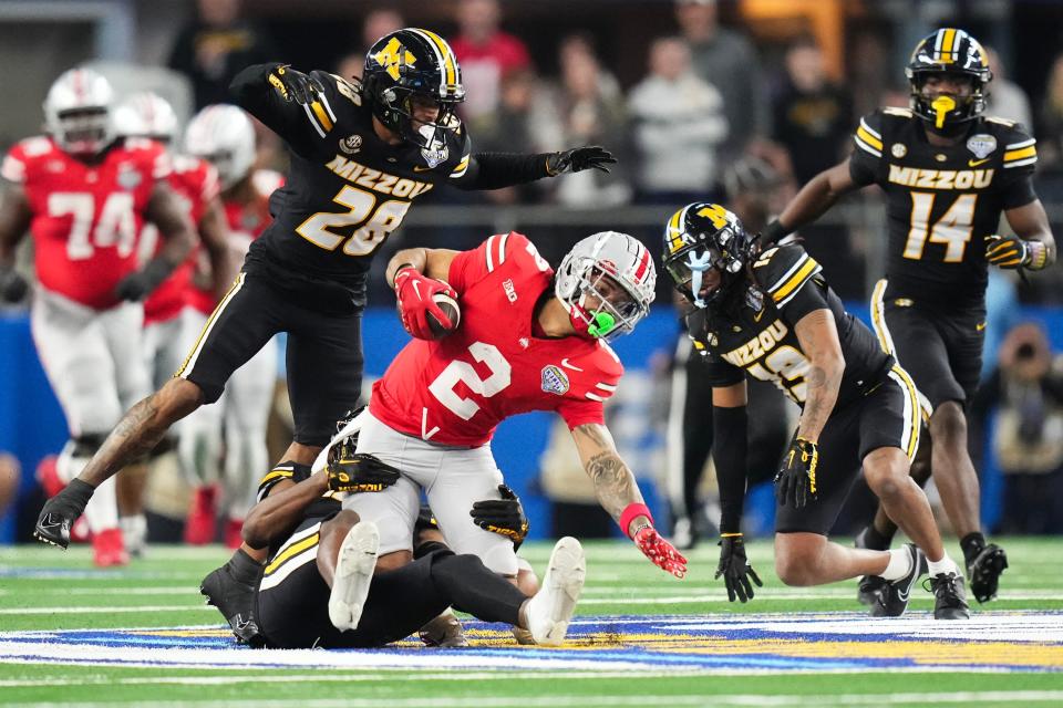 Dec 29, 2023; Arlington, Texas, USA; Missouri Tigers defensive back Jaylon Carlies (1) tackles Ohio State Buckeyes wide receiver Emeka Egbuka (2) during the fourth quarter of the Goodyear Cotton Bowl Classic at AT&T Stadium. Ohio State lost 14-3.