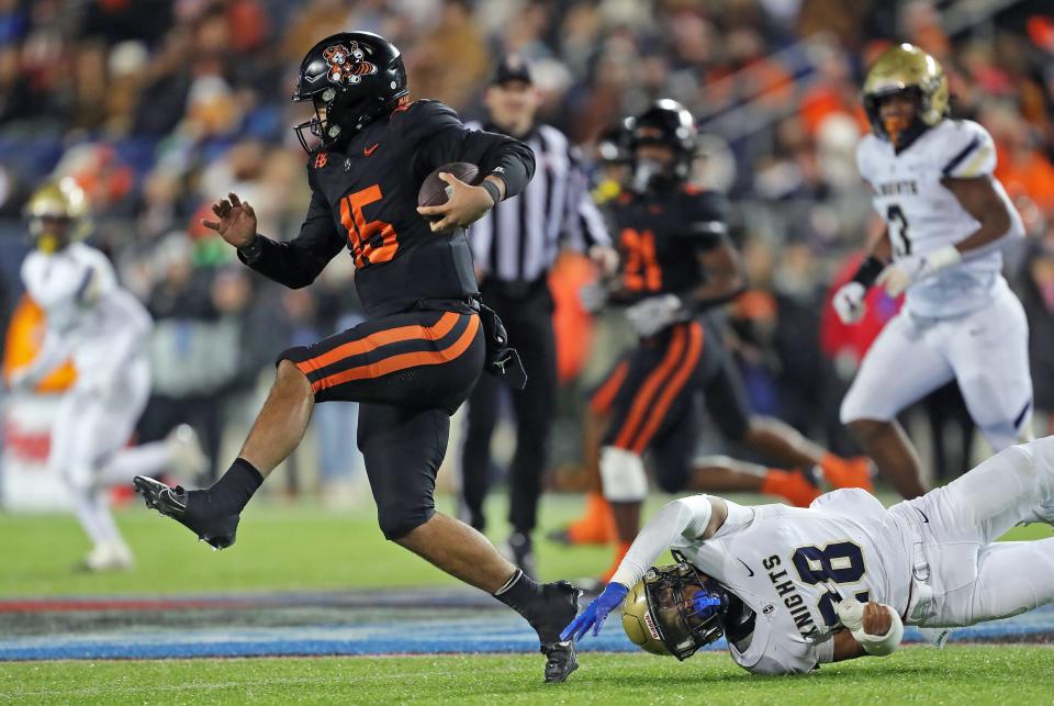 Massillon quarterback DaOne Owens sheds a tackle from Hoban linebacker Cartier Williams during the second half of the OHSAA Division II state championship game at Tom Benson Hall of Fame Stadium, Thursday, Nov. 30, 2023, in Canton.