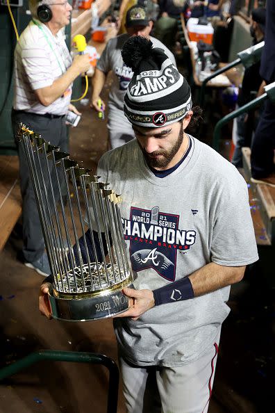 HOUSTON, TEXAS - NOVEMBER 02:  Dansby Swanson #7 of the Atlanta Braves celebrates with the Commissioner's Trophy after the team's 7-0 victory against the Houston Astros in Game Six to win the 2021 World Series at Minute Maid Park on November 02, 2021 in Houston, Texas. (Photo by Elsa/Getty Images)