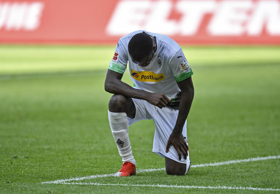 Marcus Thuram del Borussia Moenchengladbach se arrodilla tras anotar el segundo gol de su equipo en el partido contra Union Berlín por la Bundesliga, el domingo 31 de mayo de 2020. (AP Foto/Martin Meissner, Pool)