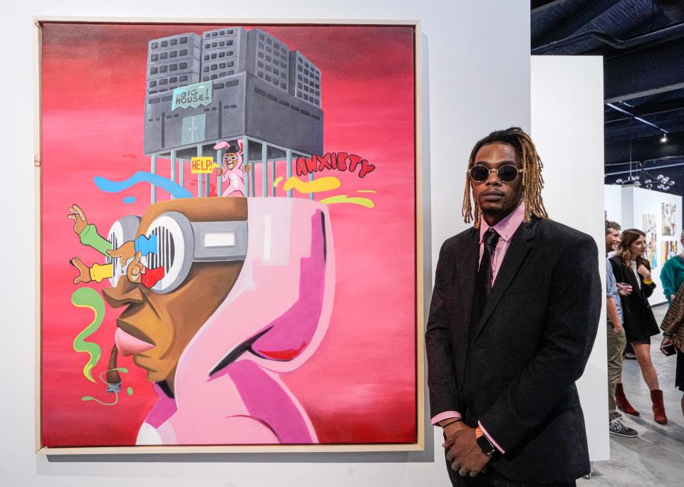 The artist "FITZ" is photographed with his work on preview night for the second annual "Butter" fine art fair presented by Ganggang on Thursday, Sept. 1, 2022, at the Stutz Building in Indianapolis. The art fair features more than 50 black artists, with a focus on equity. 