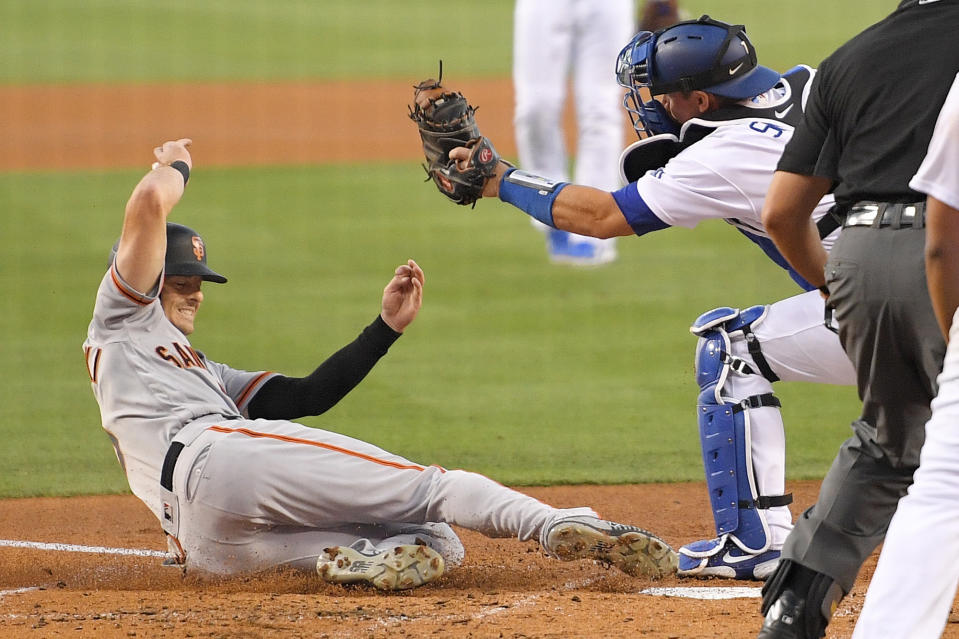 San Francisco Giants' Mike Yastrzemski, left, scores under the tag of Los Angeles Dodgers catcher Will Smith on a single by Donovan Solano during the third inning of a baseball game Friday, Aug. 7, 2020, in Los Angeles. (AP Photo/Mark J. Terrill)