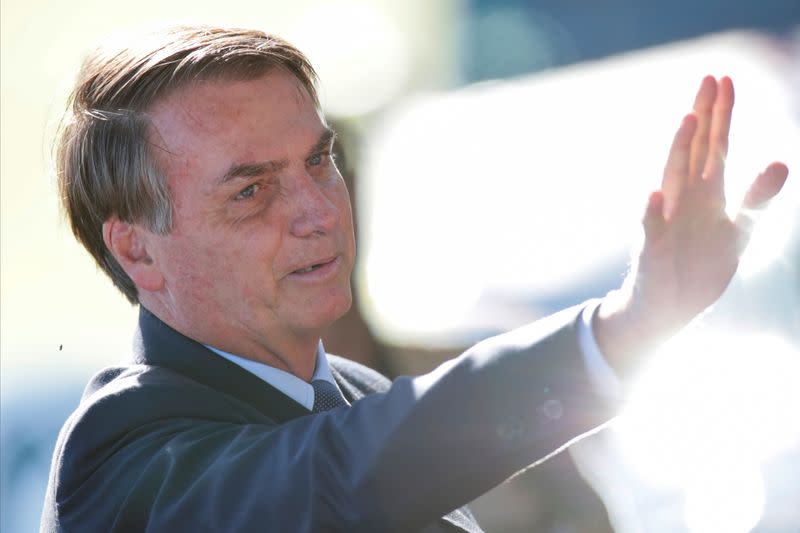 Brazil's President Jair Bolsonaro gestures while meeting supporters as he leaves at Alvorada Palace, amid coronavirus disease (COVID-19) outbreak, in Brasilia