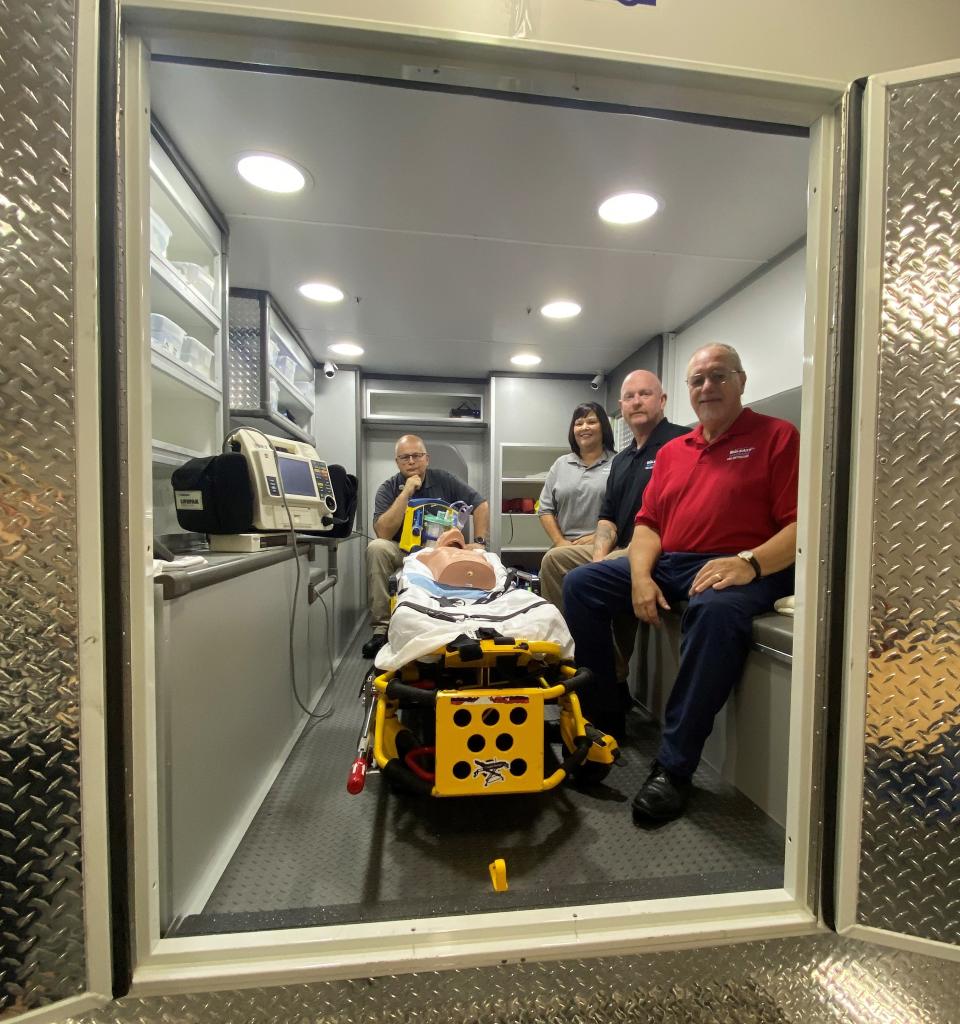 Paramedic Instructor Gary Green, EMT Instructor Shawna George, Fire Coordinator Les George and Public Safety Coordinator Mark Doerfler inside a new ambulance simulator at Mid-East Career and Technology Centers.