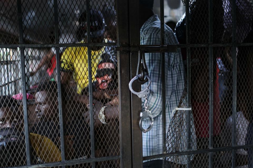 A handcuff secures the latch of a prisoner bus transporting undocumented Haitians to be deported to Haiti, in Dajabon, Dominican Republic, Friday, Nov. 19, 2021. More than 31,000 people have been deported by the Dominican Republic to Haiti this year, more than 12,000 of them in just the past three months -- a huge spike, observers say. (AP Photo/Matias Delacroix)