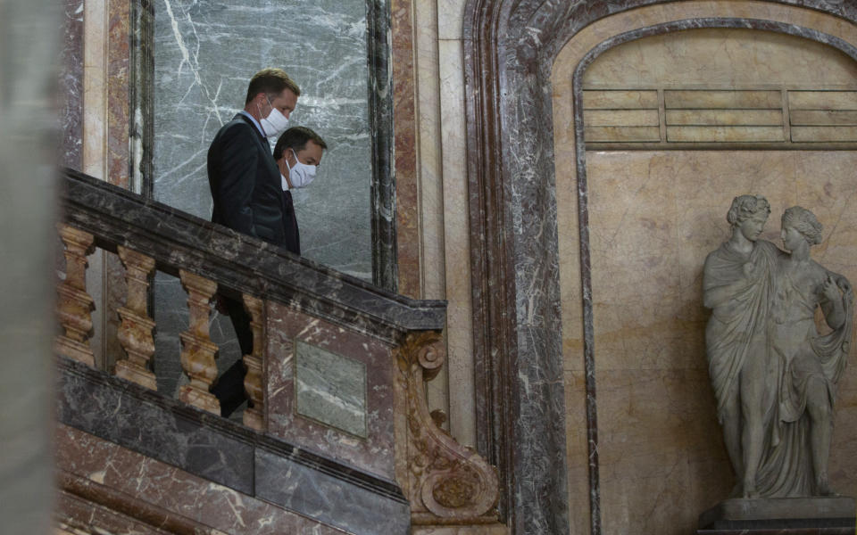 Belgian Minister of Cooperation Development and Finance, Alexander De Croo, right, and Belgian francophone Socialist Party chairman Paul Magnette walk past a statue prior to a media conference at the Egmont Palace in Brussels, Wednesday, Sept. 30, 2020. Almost 500 days after Belgian parliamentary elections, seven parties from both sides of the linguistic border have agreed on forming a fully functioning majority government that will center on dealing with the pandemic and its devastating economic impact. (AP Photo/Virginia Mayo)