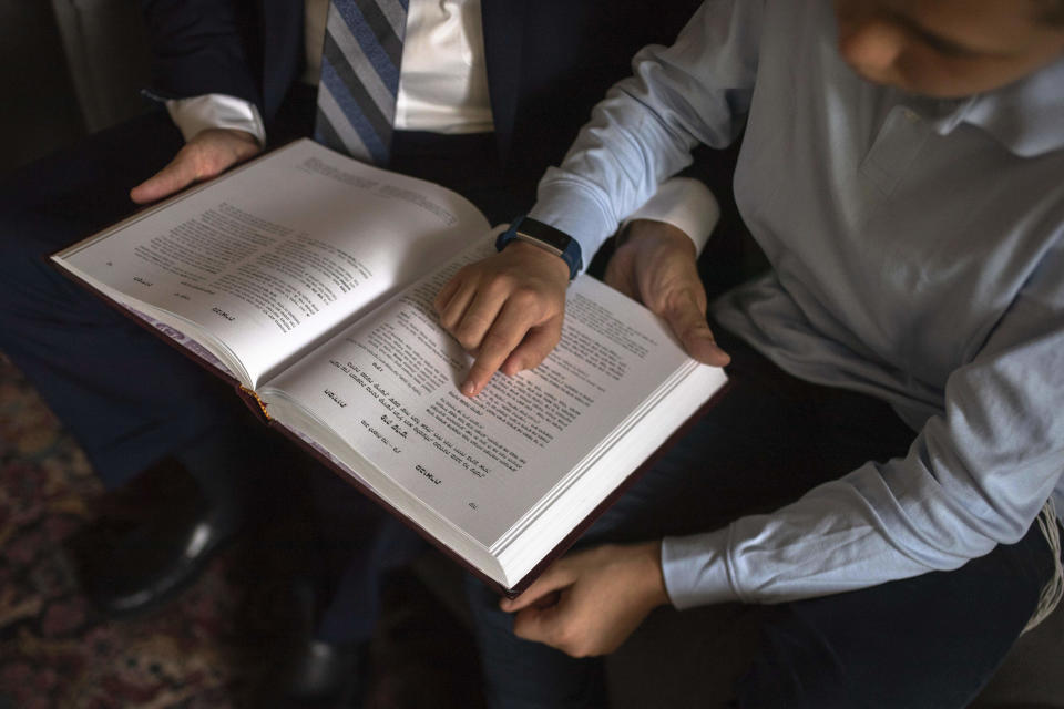 Chabad-Lubavitch Rabbi Levi Banon and his son Mendel, 12, read a religious text at their home library in Casablanca, Morocco, Thursday, May 28, 2020. (AP Photo/Mosa'ab Elshamy)