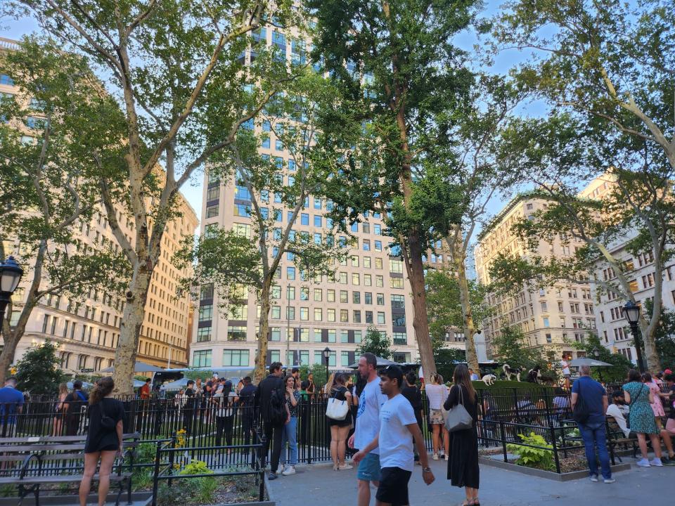 <p>A picture taken with the Galaxy Z Flip 4 showing many people walking around in a park in New York City, some are gathered around an enclosed dog run.</p>
