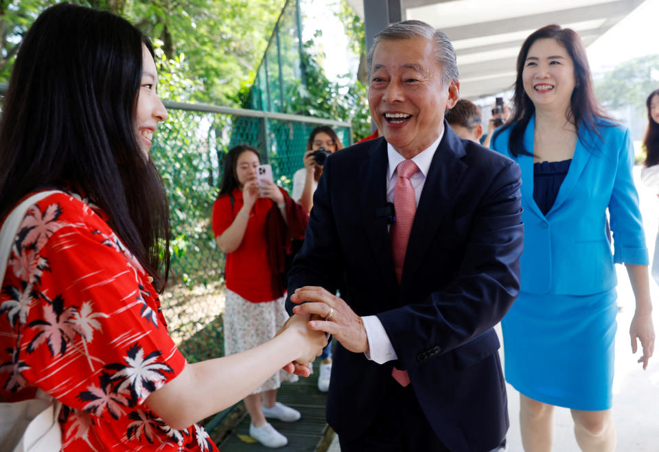 Potential presidential candidate George Goh and his wife Lysa Sumali greet supporters outside the Elections Department in Singapore.