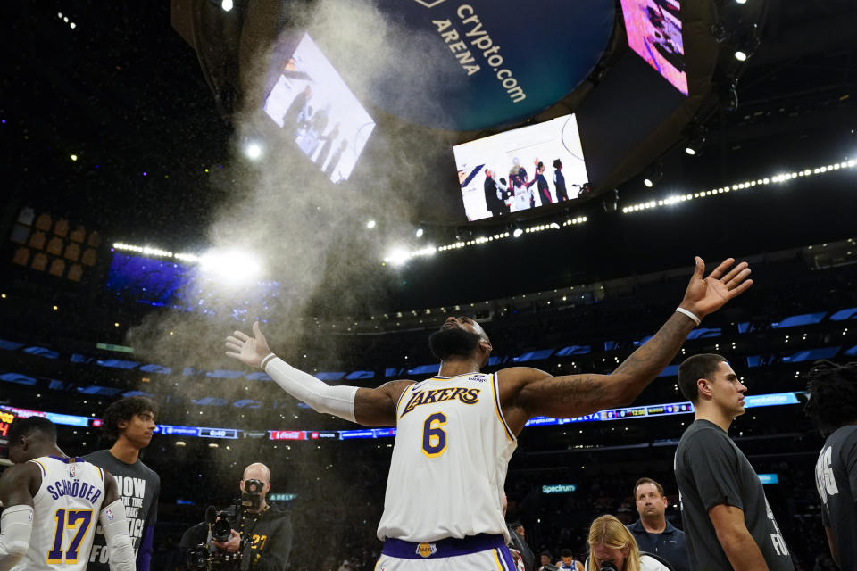 Los Angeles Lakers forward LeBron James (6) throws powdered chalk in the air before an NBA basketball game against the Philadelphia 76ers in Los Angeles, Sunday, Jan. 15, 2023. (AP Photo/Ashley Landis)