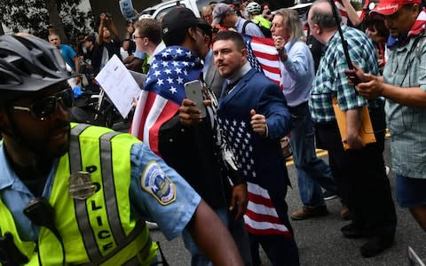 Police escort 'Unite the Right' organiser Jason Kessler and protesters during a far-right rally at Lafayette Park opposite the White House - Credit: AFP