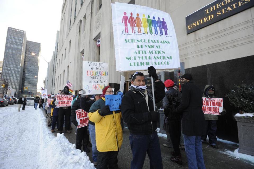 Protestors demonstrate outside Federal Courthouse before a trial that could overturn Michigan's ban on gay marriage in Detroit on Monday, March 3, 2014 in Detroit. Lisa Brown of Oakland County, the elected clerk of a Detroit-area county says she'll follow the orders of a judge when it comes to same-sex marriage, not Michigan's attorney general. Brown was asked about an email last fall from the attorney general's office, which warned county clerks not to issue marriage licenses to same-sex couples, even if a judge threw out the ban. Michigan voters banned gay marriage in 2004. In a lawsuit, Detroit-area nurses April DeBoer and Jayne Rowse say that violates the U.S. Constitution. (AP Photo/Detroit News, David Coates) DETROIT FREE PRESS OUT; HUFFINGTON POST OUT