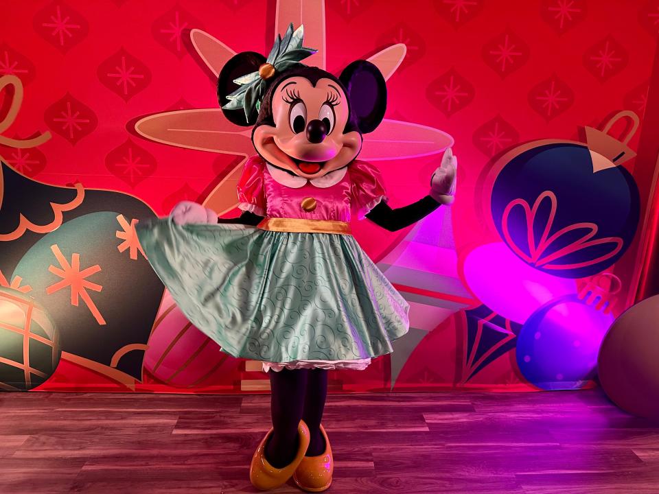 minnie mouse posing in her holiday outfit at disney world