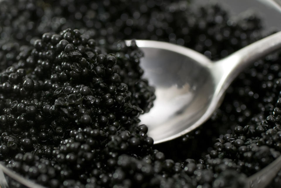 A spoon taking a scoop of caviar