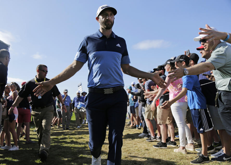 Dustin Johnson greets spectators as he walks to the 12th tee during the third round of the PGA Championship golf tournament, Saturday, May 18, 2019, at Bethpage Black in Farmingdale, N.Y. (AP Photo/Seth Wenig)