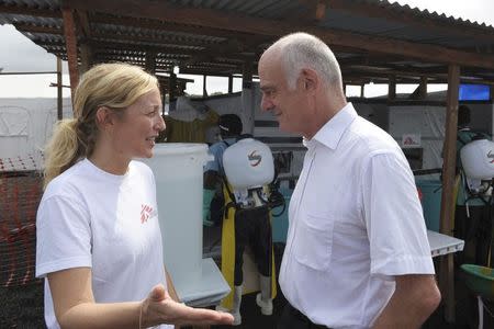 Senior United Nations (U.N.) System Coordinator for Ebola, David Nabarro (L), talks with a Medicins Sans Frontieres (MSF) health worker during his visit, outside the ELWA's hospital isolation unit in Monrovia August 23, 2014. REUTERS/2Tango