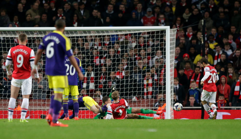 Arsenal's Mathieu Flamini, right, scores an own goal to make the final score 2-2 during the English Premier League soccer match between Arsenal and Swansea City at the Emirates Stadium in London, Tuesday, March 25, 2014. (AP Photo/Matt Dunham)