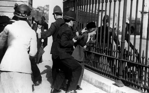 A policeman restrain a demonstrator as suffragettes gathered outside Buckingham Palace in 1914. Suffragettes campaigned vigorously in the early part of the 2Oth century to gain the right for women to vote, and one died in 1913 when she threw herself under the King's horse at the Derby. - Credit: PA/PA