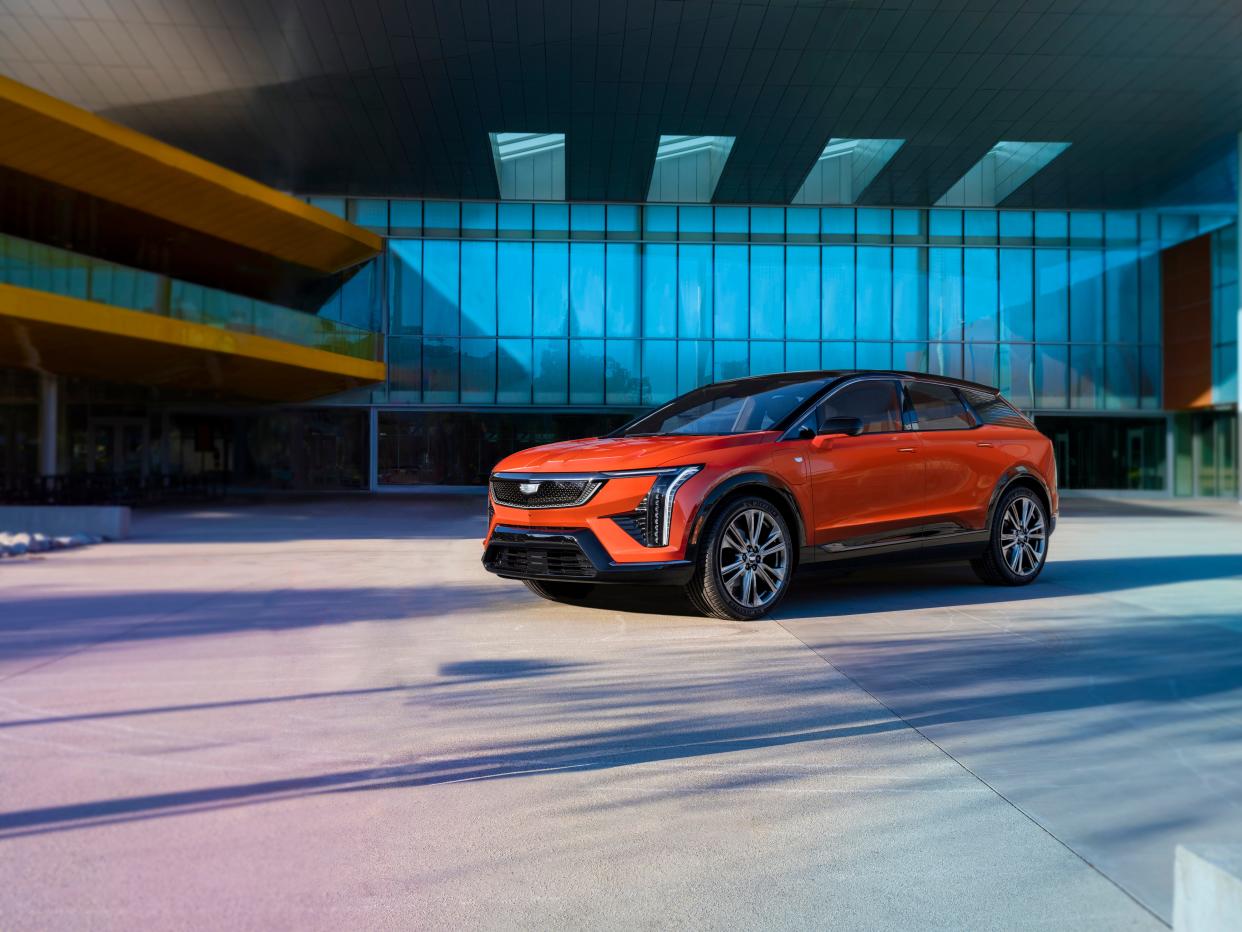 A front three-quarter view of the 2025 Cadillac Optiq compact SUV in Monarch Orange.