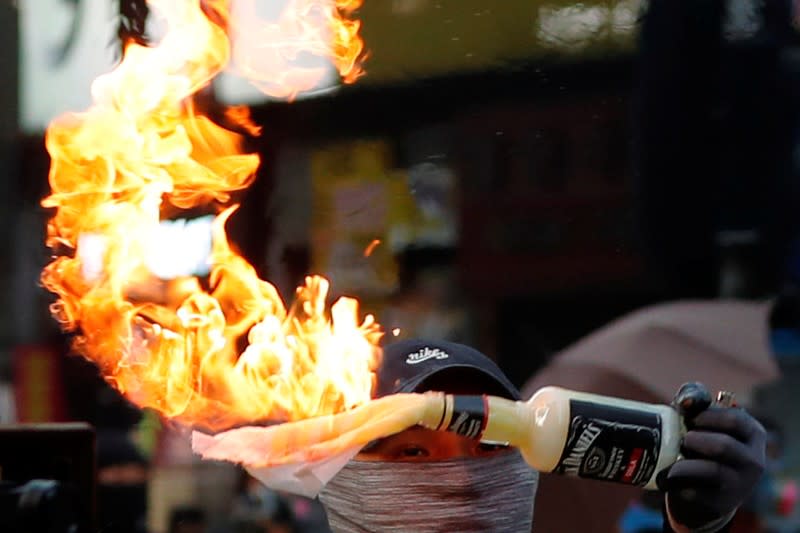 An anti-government protester holds a Molotov cocktail during a march in Hong Kong