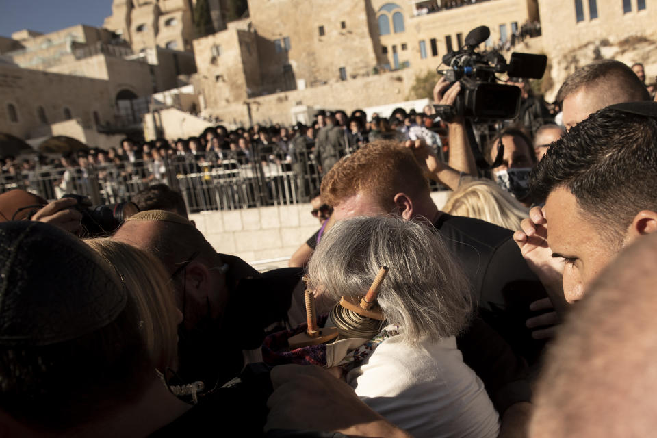 Members of the Women of the Wall clutch a Torah scroll as they are surrounded by Israeli security forces at the Western Wall, the holiest site where Jews can pray, in the Old City of Jerusalem, Friday, Nov. 5, 2021. Thousands of ultra-Orthodox Jews gathered at the site to protest against the Jewish women's group that holds monthly prayers there in a long-running campaign for gender equality at the site. (AP Photo/Maya Alleruzzo)