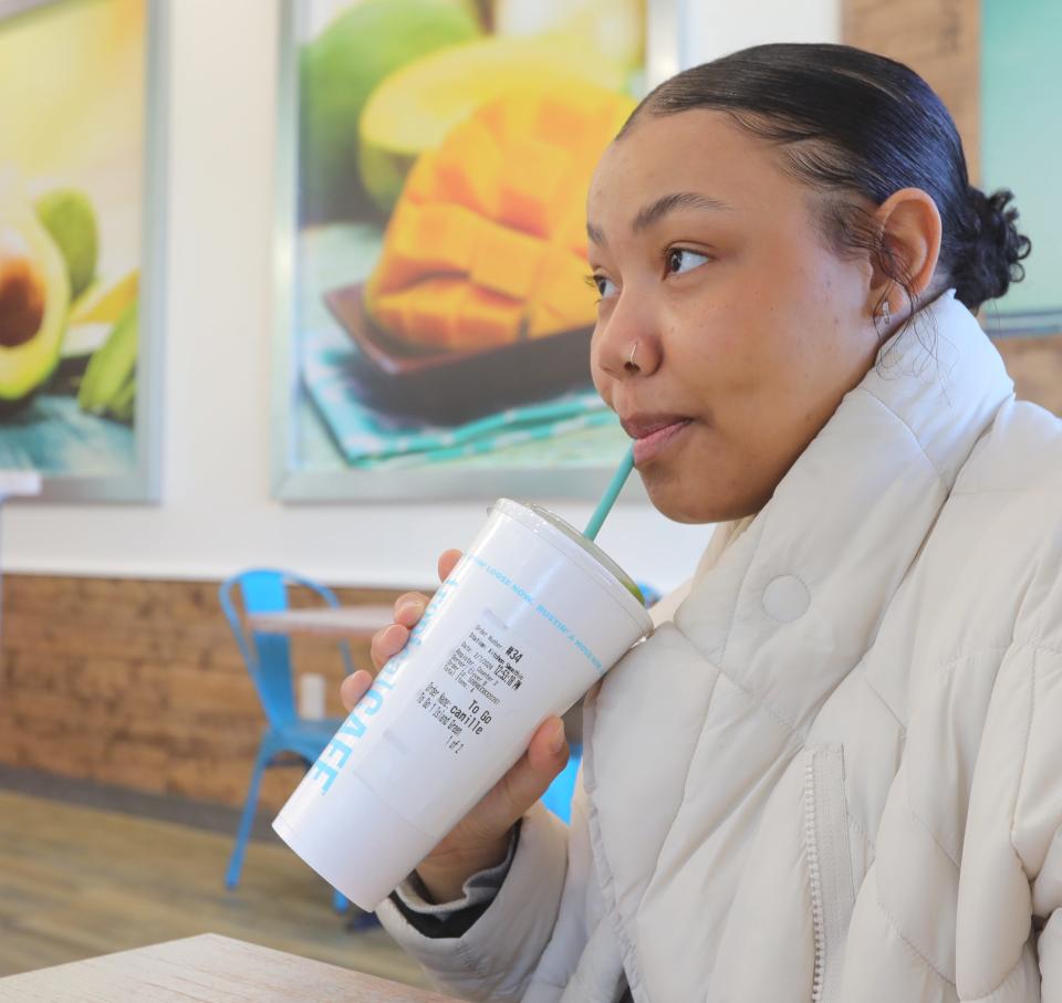 Camille Harper of Akron sips on an Island Green smoothie ($7.79) at Tropical Smoothie Cafe's new Wallhaven location, which had its soft opening Monday.