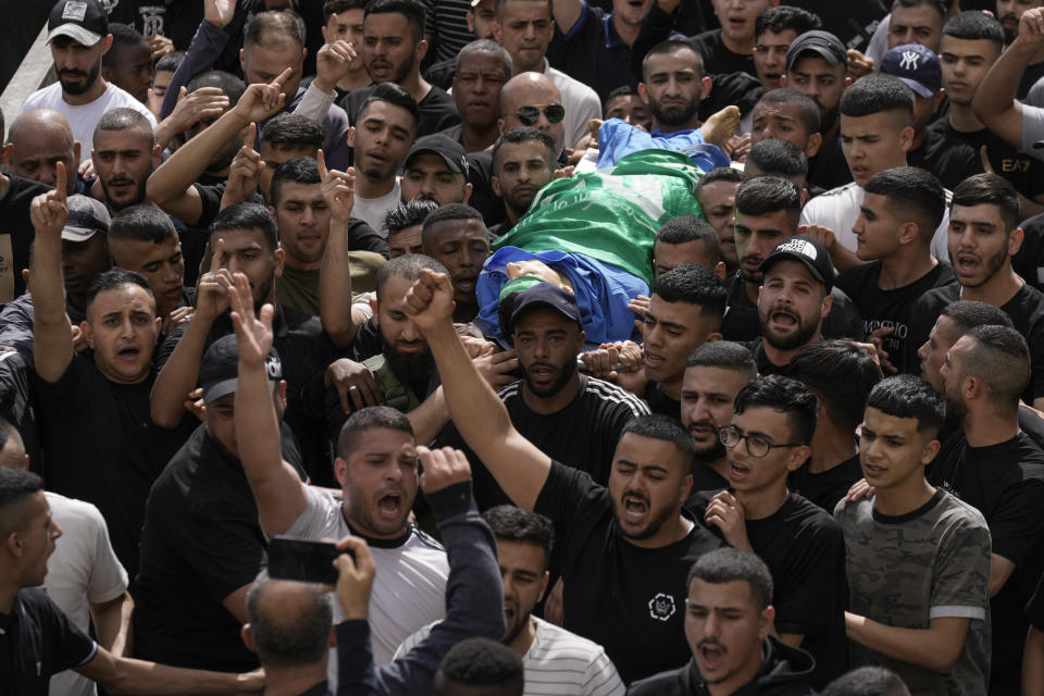 Palestinians carry the body of militant Hamza Kharyoush warped in a Hamas flag in the Nur Shams refugee camp near the city of Tulkarem, in the occupied West Bank Saturday, May 6, 2023 , Saturday, May 6, 2023. Palestinian Health Ministry says Israeli forces have shot dead two Palestinians during a military raid in the occupied West Bank, while a local armed group said the pair were militants. Saturday's deadly raid in the Nur Shams refugee camp near the city of Tulkarem was the latest in Israeli-Palestinian violence that has all but surged since last year. Palestinians said the two dead were 22 years and are members of a local armed group. (AP Photo/Majdi Mohammed)