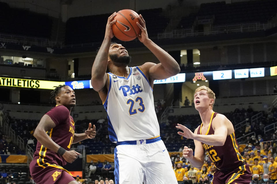 Pittsburgh's John Hugley (23) shoots between Minnesota's Charlie Daniels, left, and Luke Loewe (12) during the first half of an NCAA college basketball game Tuesday, Nov. 30, 2021, in Pittsburgh. (AP Photo/Keith Srakocic)