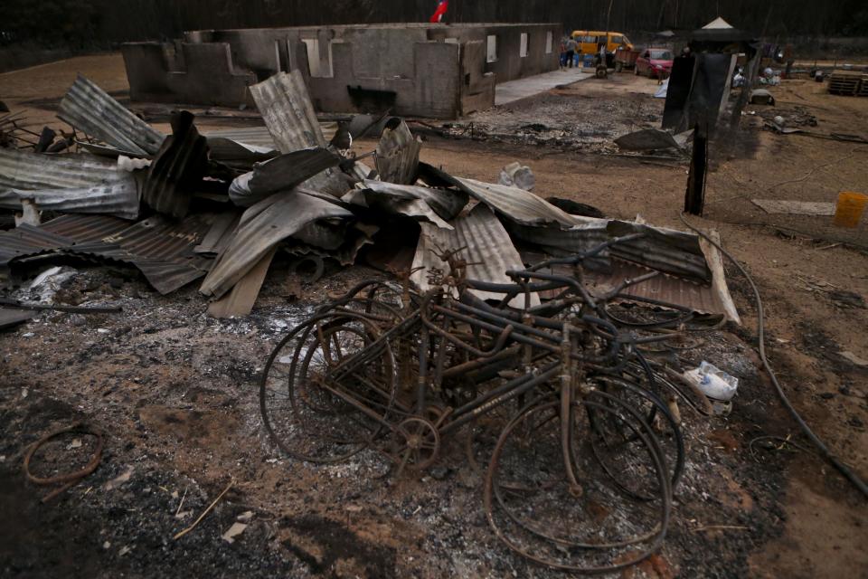 This Saturday, Jan. 21, 2016 photo shows charred bicycles amid debris left from wildfires in Pumanque, Chile. The fires have consumed forests, livestock and entire towns, prompting President Michelle Bachelet to declare a state of emergency, deploy troops and ask for international help. (AP Photo/Esteban Felix)