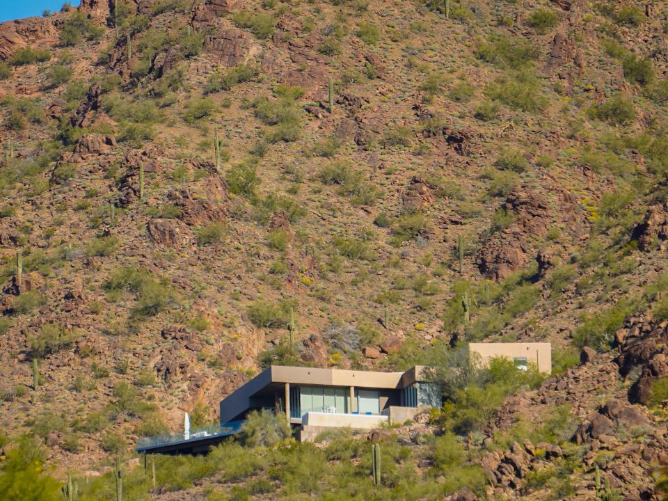 A modern estate embedded in a desert mountain.