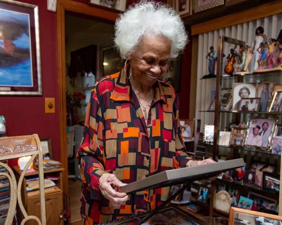 Ollie Mae Hampton Pelly looks at photos from her career at the Belvidere Assembly Plant on Wednesday, Jan. 4, 2023, in Beloit. Pelly, 84, has been an employee at the plant for 56 years.