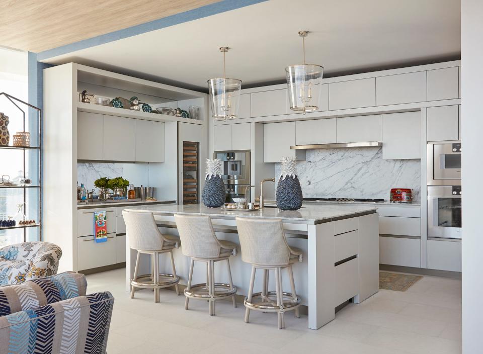 The kitchen features Italian cabinetry, marble counters and Gagggenau appliances. Cindy Galvin customized the space by adding more storage and creating a new lighting plan that includes pendants by Vaughan Designs.