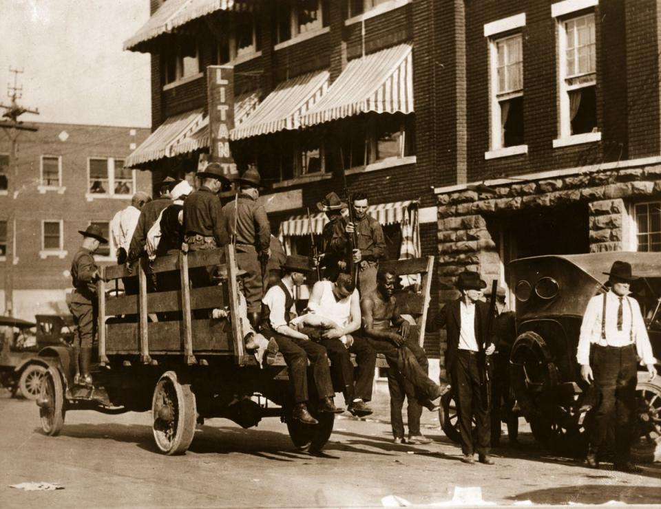 National guardsmen carry injured and wounded men in the aftermath of the Tulsa race massacre in 2021. (Getty Images)