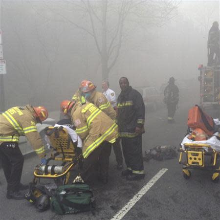 Firefighters tend to an injured person as they battle a nine-alarm blaze in Boston's Back Bay neighborhood March 26, 2014. REUTERS/Boston Fire Department