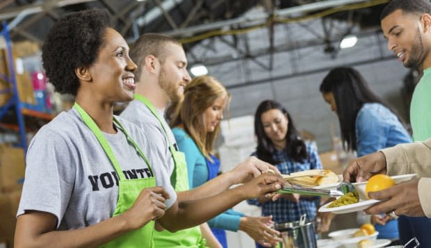 Volunteers serving healthy hot meal at soup kitchen