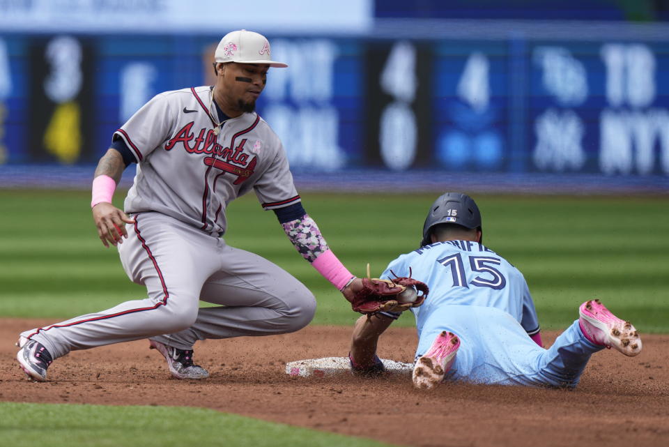 Toronto Blue Jays' Whit Merrifield (15) steals second base past a tag by Atlanta Braves shortstop Orlando Arcia (11) during baseball game action in Toronto, Ontario, Sunday, May 14, 2023. (Frank Gunn/The Canadian Press via AP)