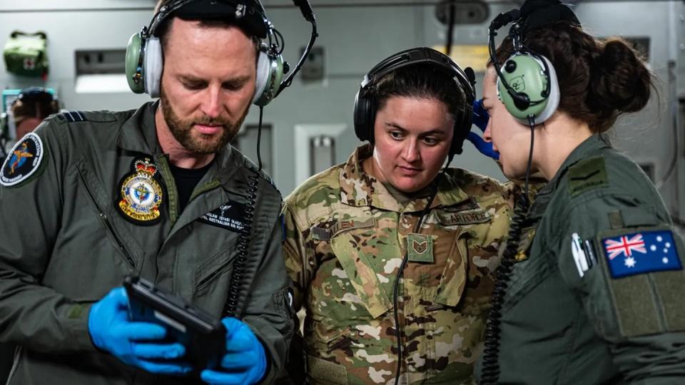 Royal Australian Air Force aviators, assigned to the 3rd Aeromedical Evacuation Squadron, and U.S. airmen, assigned to the 375th AES, conduct joint medical training July 10 on a RAAF C-17 Globemaster III over Andersen Air Force Base, Guam, for Exercise Mobility Guardian 23. (Staff Sgt. Devin Rumbaugh/Air Force)