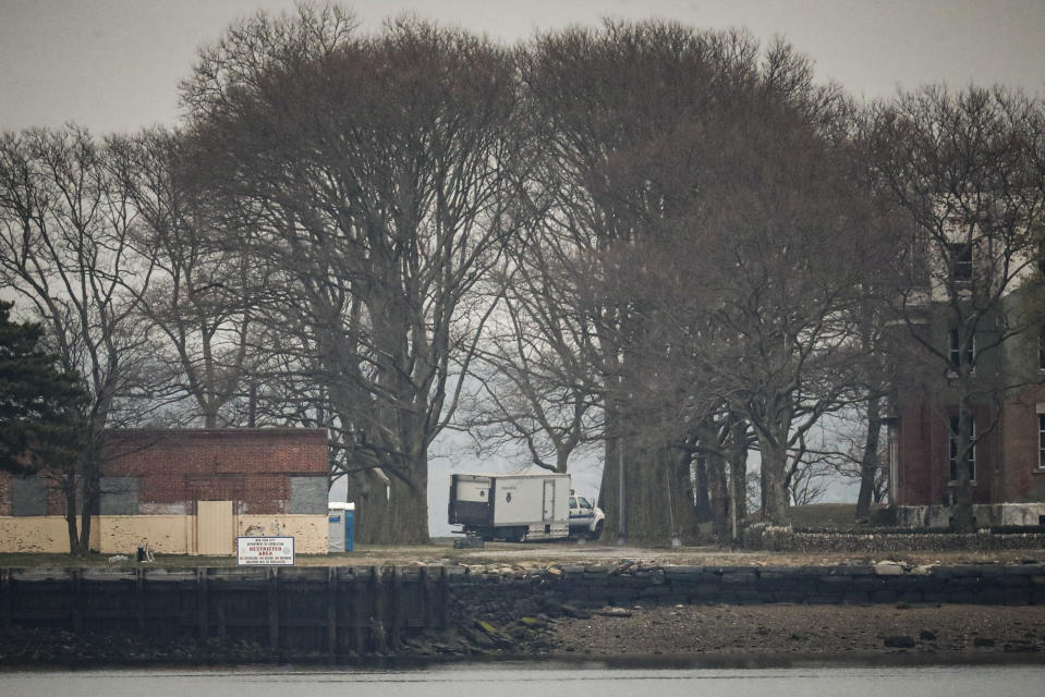 A truck loaded with bodies drives towards a burial trench on Hart Island, Thursday, April 9, 2020, in the Bronx borough of New York. New York City could bury virus victims in temporary graves if city morgues are overwhelmed. Mayor Bill DeBlasio said earlier in the week that officials have explored the possibility of temporary burials on Hart Island, a strip of land in Long Island Sound that has long served as the city’s potter’s field. The city’s 2008 Pandemic Influenza Surge Plan states that Hart Island would be used as a temporary burial site in the event the death toll reaches the tens of thousands and if other storage, such as the refrigerator trucks parked outside hospitals, is full. (AP Photo/John Minchillo)