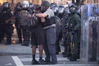 A police officer embraces a protester who helped disperse a crowd of people during a demonstration Monday, June 1, 2020, in Atlanta over the death of George Floyd, who died after being restrained by Minneapolis police officers on May 25. (AP Photo/John Bazemore)