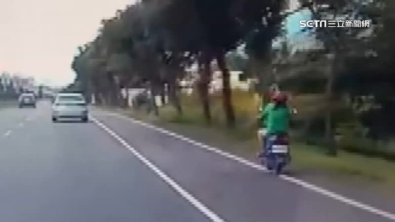 婦人騎車載著孩童在車道上，卻越騎越偏。