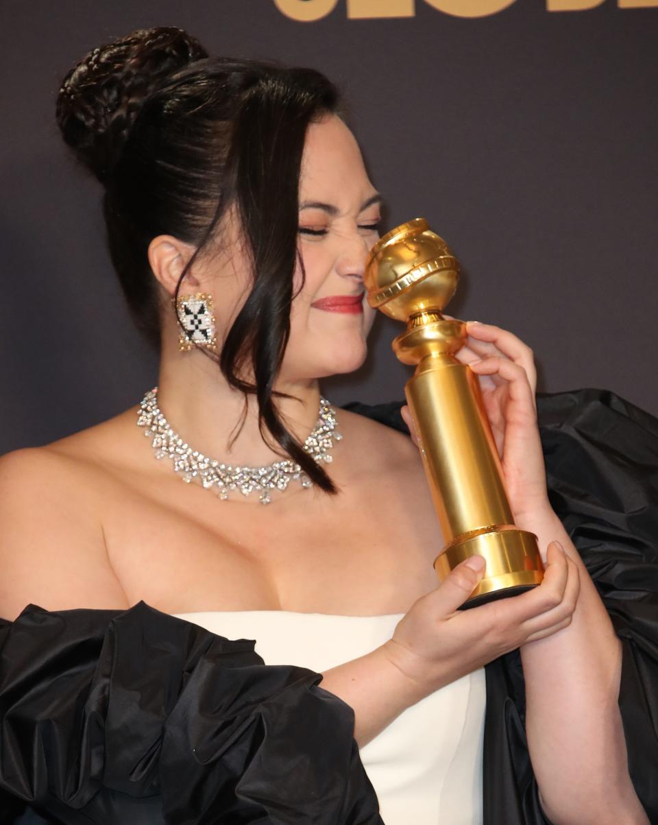 First-time Golden Globe winner Lily Gladstone nuzzles up to her trophy for best actress in a drama.