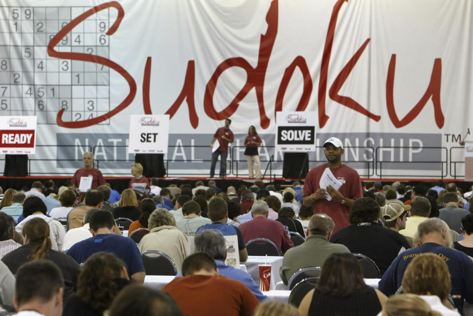 FILE - In this Oct. 20, 2007, file photo, a tournament official, white hat, watches for participants to complete their puzzles during the Sudoku Tournament in Philadelphia. Maki Kaji, known as the “Godfather of Sudoku,” the numbers puzzle he created that’s drawn fans around the world, has died, a spokesman for his Japanese company said Tuesday, Aug. 17, 2021. He was 69.(AP Photo/ Joseph Kaczmarek, File)