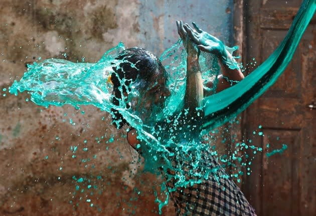 A girl gets doused with colored water while celebrating Holi, the Hindu Festival of Colors, in Mumbai, India, on March 13, 2017. <a href="https://www.theatlantic.com/photo/2017/03/holi-2017-the-festival-of-colors/519363/" rel="nofollow noopener" target="_blank" data-ylk="slk:See more scenes from the celebration here;elm:context_link;itc:0;sec:content-canvas" class="link ">See more scenes from the celebration here</a>. (Shailesh Andrade / Reuters)