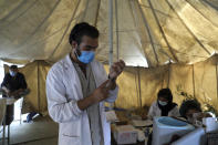 FILE - A doctor fills a syringe with the Johnson & Johnson COVID-19 vaccine donated through the U.N.-backed COVAX program at a vaccination center in Kabul, Afghanistan, Sunday, July 11, 2021. COVAX, created to share coronavirus vaccines fairly, already scaled back its pledge to the world's poor once. Now, to meet even that limited promise, it would have to deliver more than a million doses every hour until the end of the year. (AP Photo/Rahmat Gul, File)